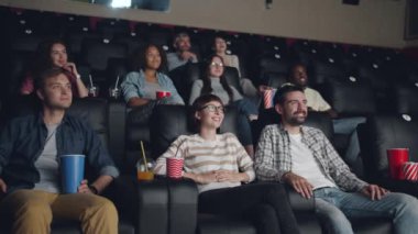 Mutlu kızlar ve çocuklar sinemada film izlerken eğlenmek gülüyor
