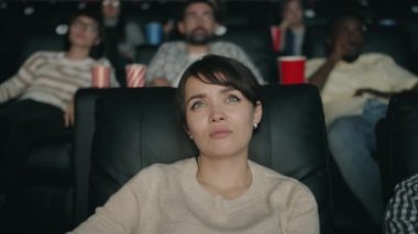 Güzel bayan karanlık salonda oturan sinemada hüzünlü film melodram izliyor