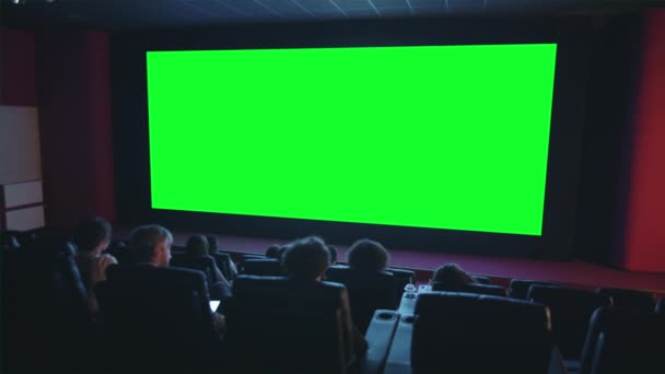 Slow motion of viewers clapping hands looking at green chroma key cinema screen — Stock Video