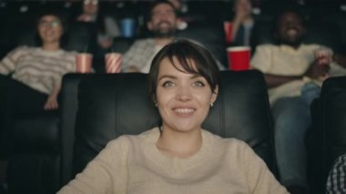 Sinemada gülerek film izlerken eğlenen güzel esmer portresi