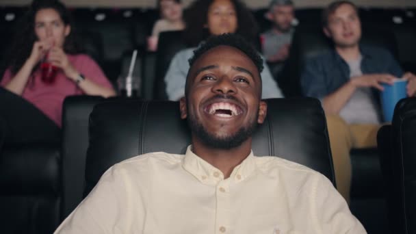 Happy African American man laughing in cinema watching funny comedy — Stock Video