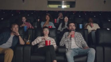 Sinema yemek film izlerken öğrencilerin çok ırklı grup yavaş hareket
