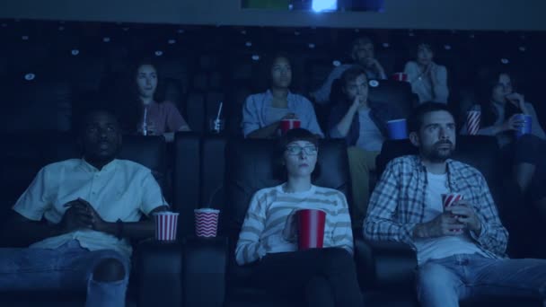 Slow motion of emotional people watching scary movie in cinema closing eyes — Stock Video