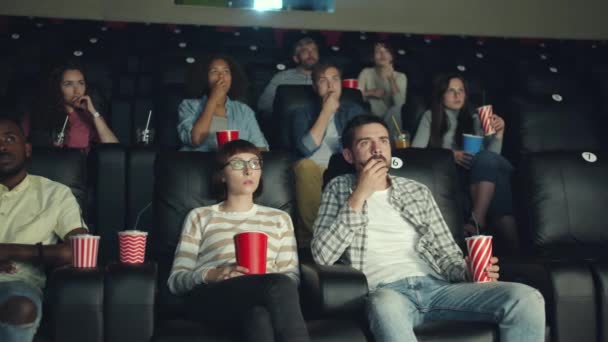 Emotional viewers enjoying scary thriller in cinema watching film with attention — Stock Video
