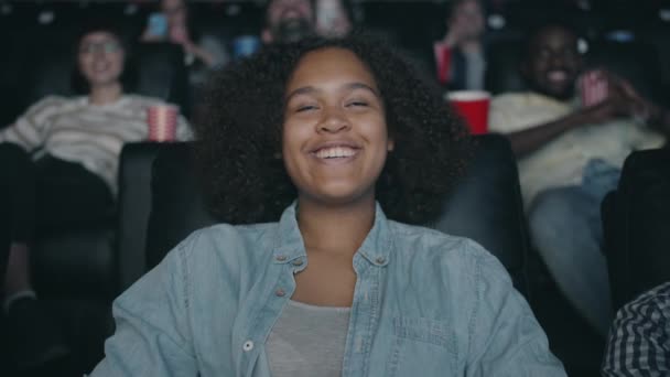 Slow Motion van vrolijke Afro-Amerikaanse vrouw genieten van film in de bioscoop lachen — Stockvideo