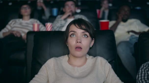 Slow motion of beautiful woman watching film in cinema with open mouth drinking — Stock Video