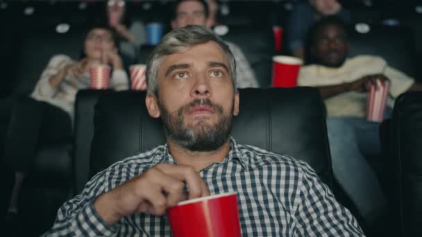 Slow motion of mature man opening mouth watching shocking film in cinema — Stock Video
