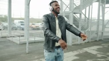 Mutlu Afro-Amerikan öğrenci kulaklık la dans açık havada eğlenmek