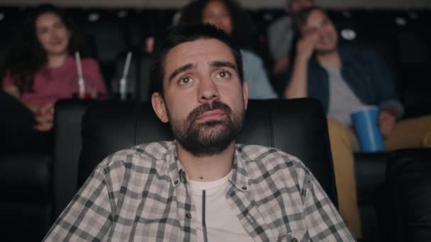 Slow motion of handsome bearded man watching sad movie in cinema — Stock Video
