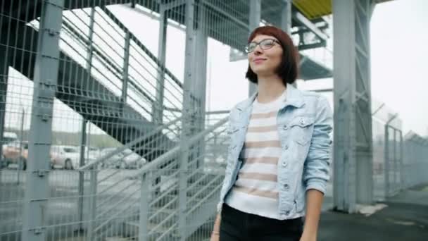 Портрет повільного руху гарненької студентки, що йде на відкритому повітрі з щасливим обличчям — стокове відео