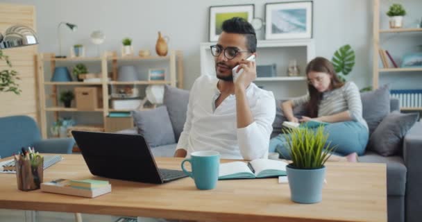 Arabe homme d'affaires parlant sur téléphone portable tout en femme lecture livre — Video