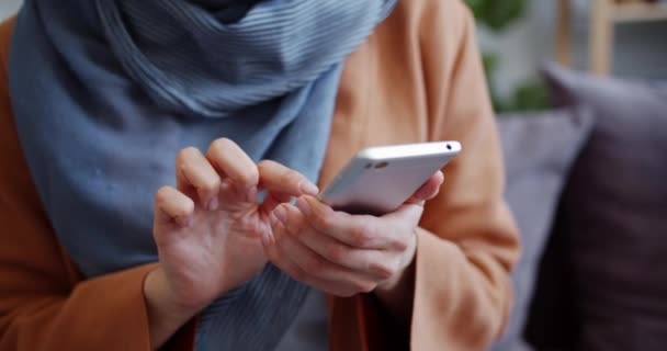 Közeli lövés a női kéz gazdaság okostelefon megható képernyő beltéri — Stock videók