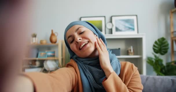 Punto di vista della donna mediorientale in hijab scattare selfie a casa guardando la fotocamera — Video Stock