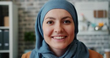 Ofiste gülümseyen türbanlı güzel Orta Doğulu kızın yakın çekim portresi