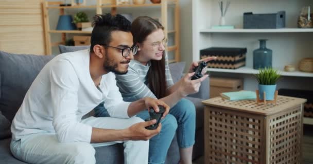 Arabian guy playing video game with cute girlfriend indoors at home — Stock Video