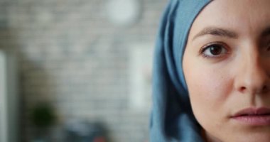 Tuğla duvar arka plan üzerinde hijab yarım yüz Müslüman kadının yakın çekim portre