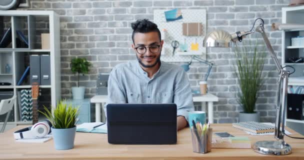 Slow motion di arabo ufficio lavoratore utilizzando laptop sorridente a scrivania sul posto di lavoro — Video Stock