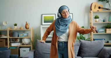 Evde kulaklık dans hijab mutlu karışık yarış kız yavaş hareket