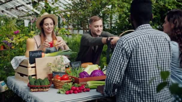 Verkoper die biologische producten aan klanten geeft in de markt van broeikasgassen — Stockvideo