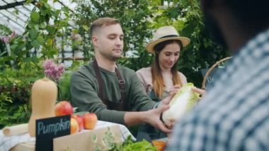 Eşi not alırken çiftlik satışı sırasında kağıt torbaiçinde sebze ambalaj Satıcı