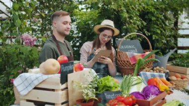 Aprons mutlu çiftçiler in sera kız not alma çiftlik satışı sırasında konuşurken
