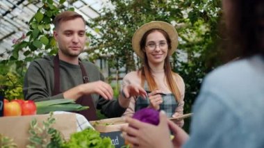 Dost satış insanlar müşterilere konuşurken çiftlik pazarında organik gıda ambalaj