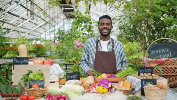 Portret van African American verkoper die biologisch voedsel verkoopt in de boerderij markt — Stockvideo