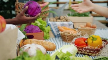 Çiftlik pazarında tezgahtan lahana ve ekmek alan ellerin yakın çekim