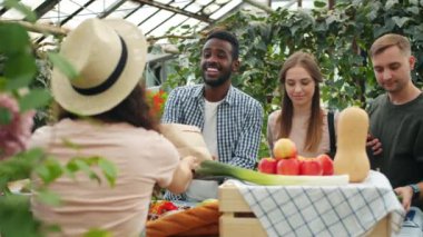 Mutlu gençler pazarda kadın çiftçi konuşuyor organik gıda satın alma