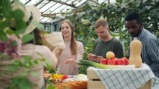 People multi-ethnic group buying organic food in farm market taking paper bags — 비디오