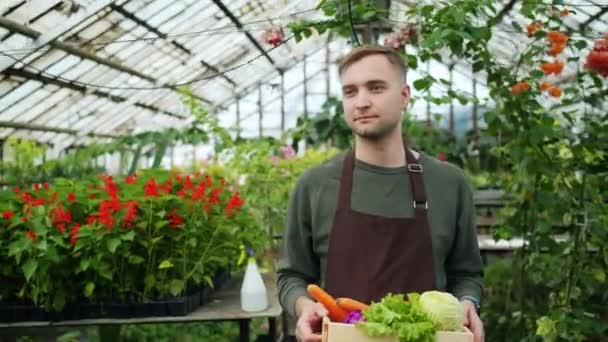 Rallentatore dell'uomo bello che cammina nella scatola di contenimento della serra di alimento organico — Video Stock