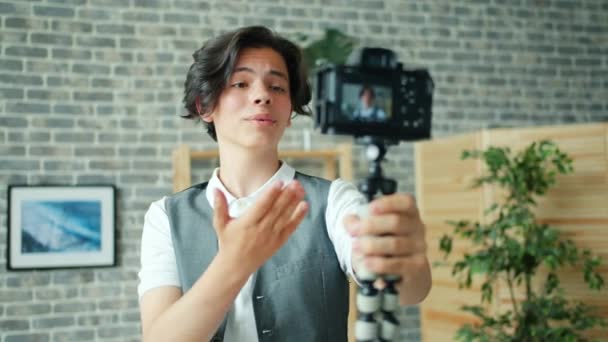 Creative student nagrywanie wideo trzymając aparat rozmowy wskazując w domu — Wideo stockowe