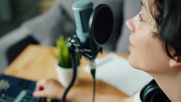 Gros plan de beau adolescent parlant en studio d'enregistrement à l'aide de matériel — Video