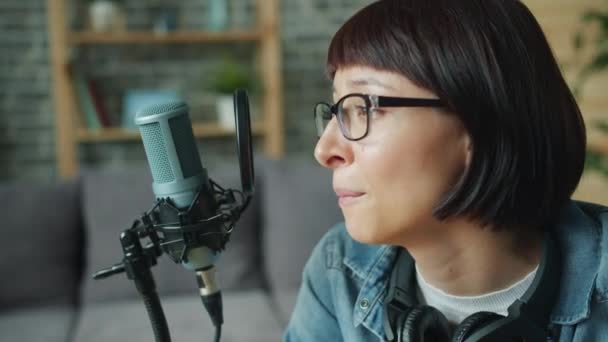 Vrolijke jonge dame praten opnemen audio met behulp van microfoon in het appartement — Stockvideo