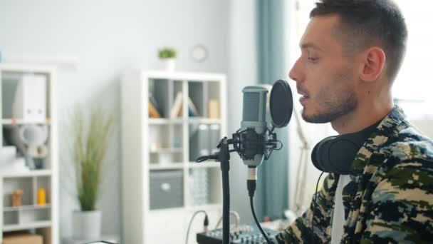 Aantrekkelijke kerel spreekt in microfoon opname podcast voor online blog — Stockvideo