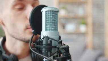 Stüdyoda mikrofon kayıt podcast konuşan erkek blogger yakın çekim