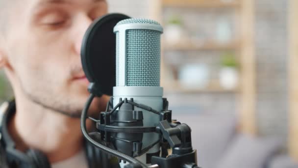 Nahaufnahme eines männlichen Bloggers, der in Mikrofon-Aufnahmepodcast im Studio spricht — Stockvideo