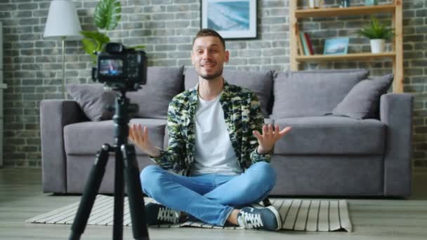 Tripod üzerinde kamera kullanarak gesturing konuşan blog için Man vlogger kayıt video — Stok video