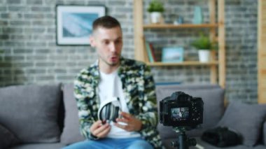 Kamera bakarak konuşurken kulaklıklar hakkında erkek blogger kayıt video