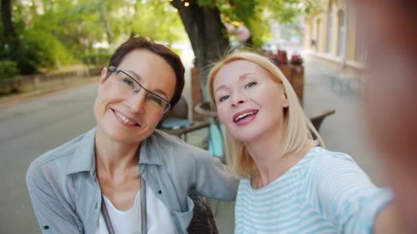 POV of attractive ladies taking selfie outdoors in cafe posing having fun — Stock Video
