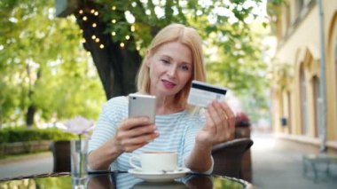 Açık kafede internet mağazasında kredi kartı ile online ödeme neşeli kadın