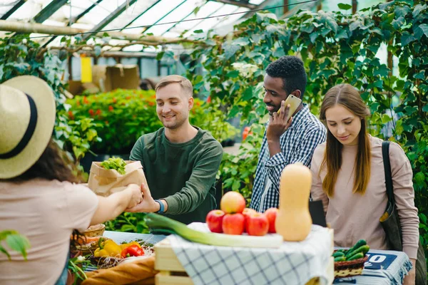 Grupo de clientes escolhendo alimentos orgânicos no mercado conversando com mulher de vendas — Fotografia de Stock