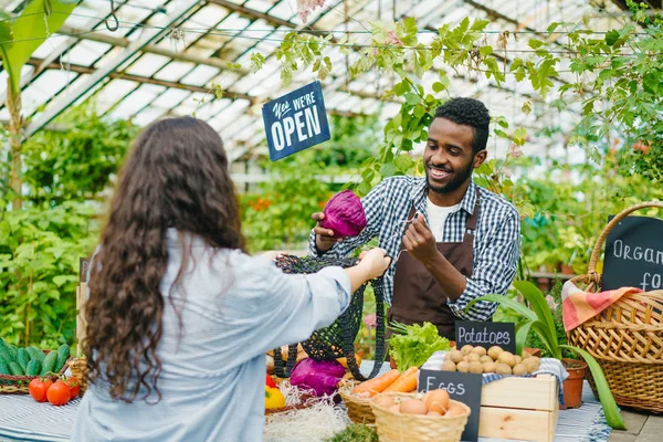 Vrouwelijke klant het kopen van biologische voedsel groenten kool in de boerderij markt — Stockfoto