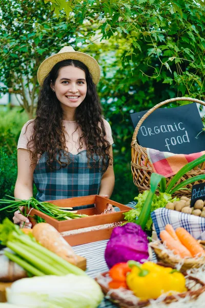 Портрет привабливої леді фермера, що продає органічну їжу на фермерському ринку посміхається — стокове фото
