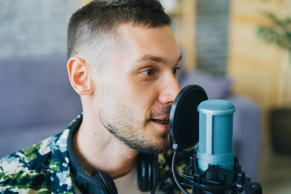 Gros plan du blogueur masculin parlant dans un podcast d'enregistrement de microphone en studio — Photo