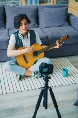 Mutlu çocuk vlogger vlog için gitar kayıt video oynarken yüksek açı görünümü