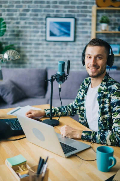 Portrait du gars dans les écouteurs en studio d'enregistrement en utilisant micro regardant la caméra — Photo