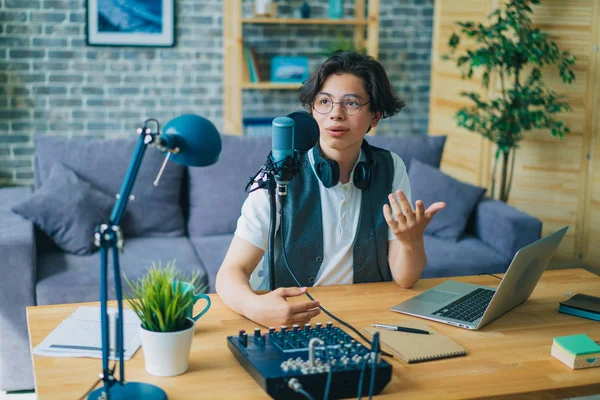 Creative teenage blogger recording podcast audio in microphone at home — Stock Photo, Image