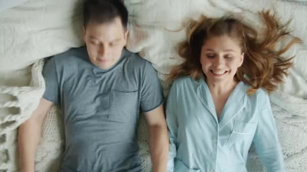 Movimento lento de amor casal marido e mulher caindo na cama sorrindo relaxante — Vídeo de Stock