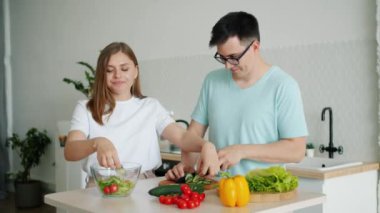 Karı koca birlikte evde mutfakta sebze kesme salata pişirme
